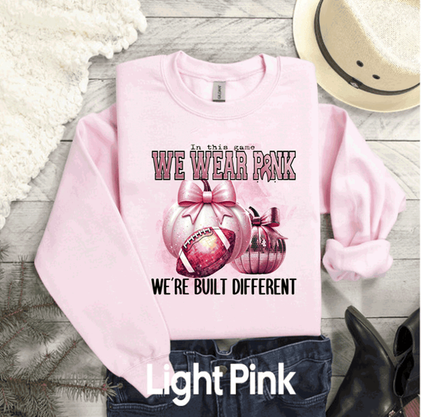 In this game we wear PINK, we're built Different, Breast PINK OUT Sweatshirt, Spirit Wear Sweatshirt, Custom October We wear Pink, Breast Cancer Awareness Month